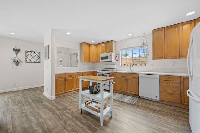 1125 Arcadia Rd, Encinitas, CA 92024 - kitchen with white appliances, wood finished floors, light countertops, recessed lighting, and brown cabinetry