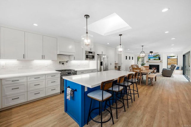 1125 Arcadia Rd, Encinitas, CA 92024 - kitchen featuring stainless steel appliances, a skylight, white cabinets, light wood-type flooring, and recessed lighting