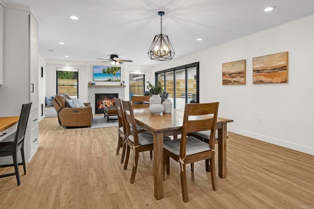 1125 Arcadia Rd, Encinitas, CA 92024 - dining space with a glass covered fireplace, light wood-type flooring, ceiling fan, recessed lighting, and a chandelier