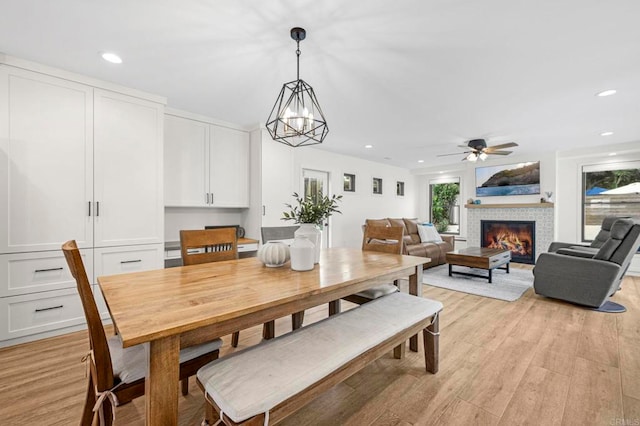 1125 Arcadia Rd, Encinitas, CA 92024 - dining area with light wood-type flooring, recessed lighting, a glass covered fireplace, ceiling fan, and a chandelier