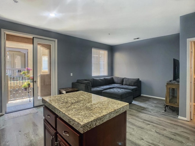 7755 Via Montebello Unit 2, San Diego, CA 92129 - kitchen with light wood-style flooring, light countertops, a kitchen island, and dark brown cabinets