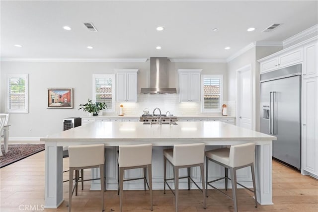 288 Shorey Dr, Glendora, CA 91741 - kitchen with built in fridge, wall chimney range hood, a sink, white cabinets, and light countertops