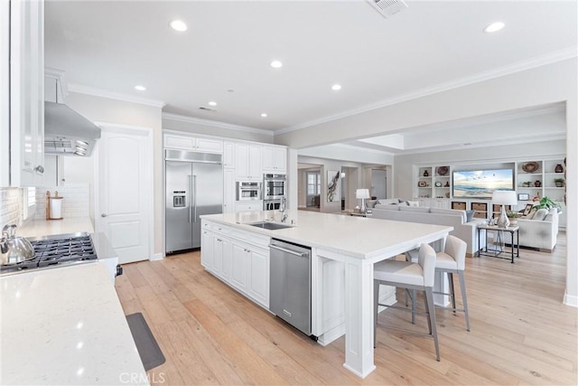 288 Shorey Dr, Glendora, CA 91741 - kitchen featuring appliances with stainless steel finishes, wall chimney exhaust hood, a large island with sink, crown molding, and open floor plan