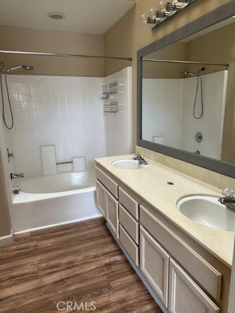 25055 Calle Playa Unit F, Laguna Niguel, CA 92677 - bathroom featuring shower / tub combination, double vanity, and wood finished floors