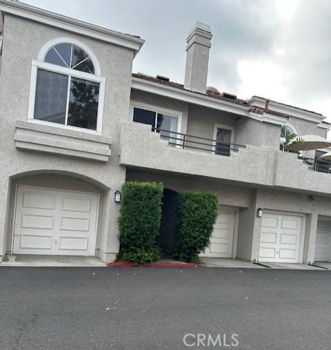 25055 Calle Playa Unit F, Laguna Niguel, CA 92677 - view of property with a balcony, a chimney, and stucco siding
