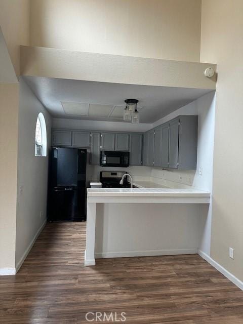 25055 Calle Playa Unit F, Laguna Niguel, CA 92677 - kitchen with black appliances, gray cabinets, a peninsula, and dark wood finished floors