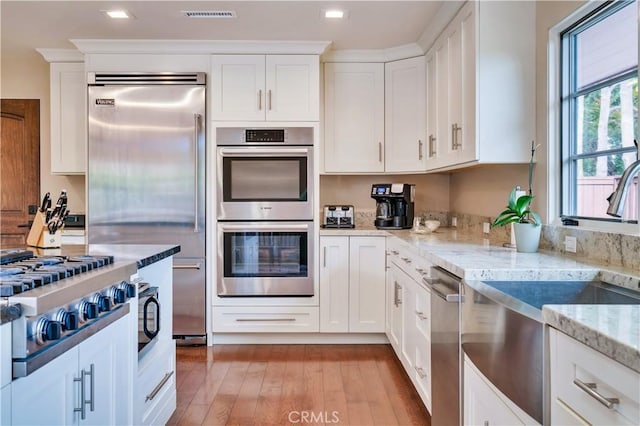 128 Rocky Point Rd, Palos Verdes Estates, CA 90274 - kitchen featuring appliances with stainless steel finishes, light wood-style flooring, a sink, white cabinetry, and recessed lighting