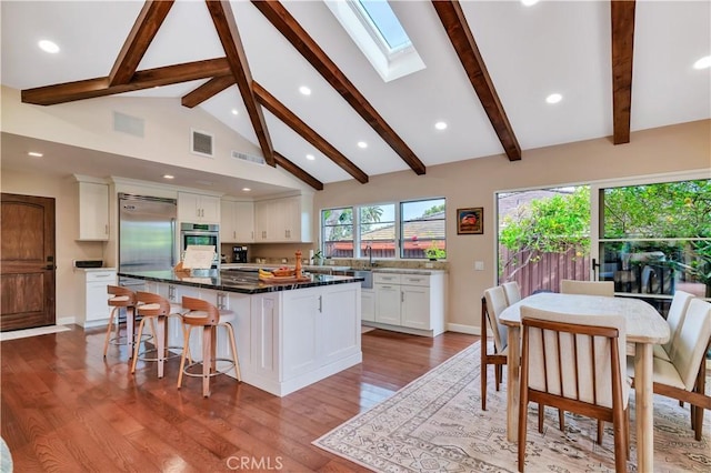 128 Rocky Point Rd, Palos Verdes Estates, CA 90274 - kitchen with white cabinetry, a center island, stainless steel built in refrigerator, beamed ceiling, and a skylight