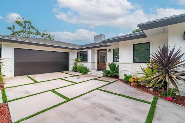 128 Rocky Point Rd, Palos Verdes Estates, CA 90274 - view of front facade with stone siding, stucco siding, concrete driveway, and an attached garage