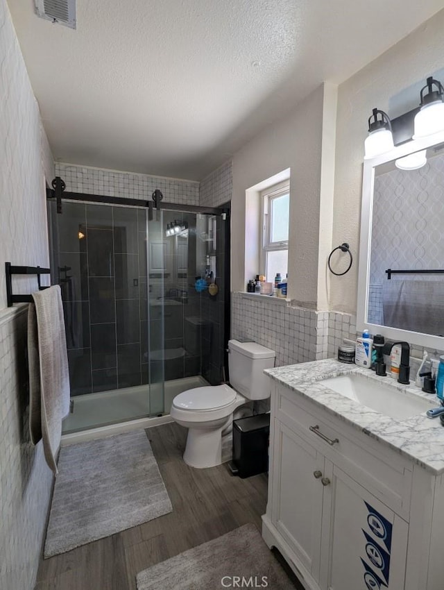 751 Glenwood Ln, Willows, CA 95988 - bathroom with wood finished floors, toilet, vanity, a stall shower, and a textured ceiling