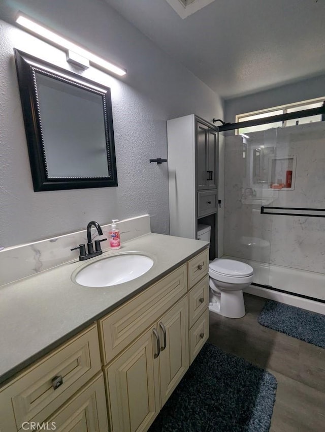 751 Glenwood Ln, Willows, CA 95988 - bathroom featuring toilet, a stall shower, vanity, a textured wall, and wood finished floors