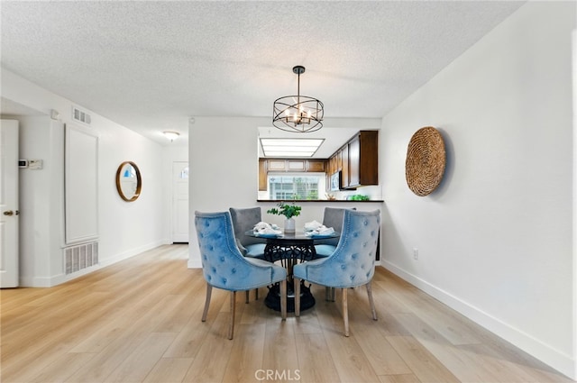 1406 Brett Pl Unit 112, San Pedro, CA 90732 - dining room with light wood-style floors, a textured ceiling, and a chandelier