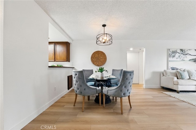 1406 Brett Pl Unit 112, San Pedro, CA 90732 - dining room featuring a textured ceiling, a chandelier, and light wood-style flooring