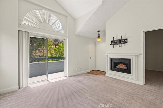 26904 Flo Ln Unit 456, Canyon Country, CA 91351 - unfurnished living room featuring carpet floors, a glass covered fireplace, baseboards, and high vaulted ceiling