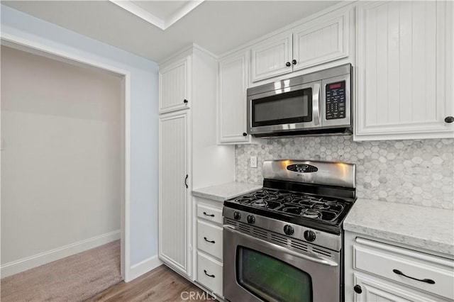 26904 Flo Ln Unit 456, Canyon Country, CA 91351 - kitchen with stainless steel appliances, backsplash, and white cabinets
