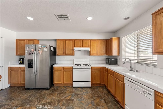 16029 White Mountain Pl, Victorville, CA 92394 - kitchen with white appliances, a sink, under cabinet range hood, a textured ceiling, and brown cabinets
