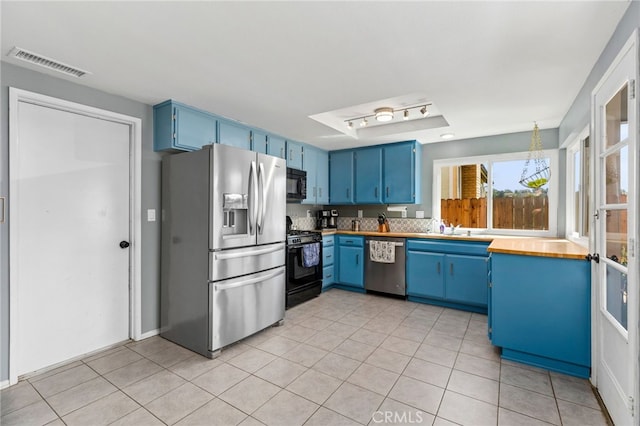 29951 Cactus Pl, Temecula, CA 92592 - kitchen featuring black appliances, blue cabinetry, light tile patterned floors, and light countertops