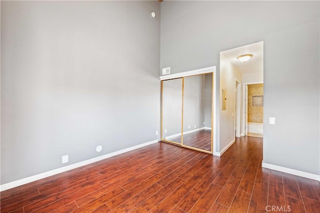 5460 White Oak Ave Unit E339, Encino, CA 91316 - unfurnished bedroom with dark wood-style flooring, a closet, and baseboards