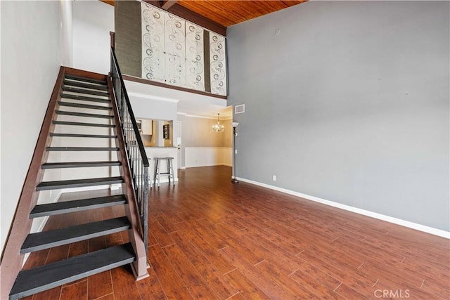 5460 White Oak Ave Unit E339, Encino, CA 91316 - staircase featuring wooden ceiling, baseboards, wood finished floors, a high ceiling, and a chandelier