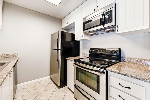 5460 White Oak Ave Unit E339, Encino, CA 91316 - kitchen featuring appliances with stainless steel finishes, white cabinets, light tile patterned floors, and baseboards