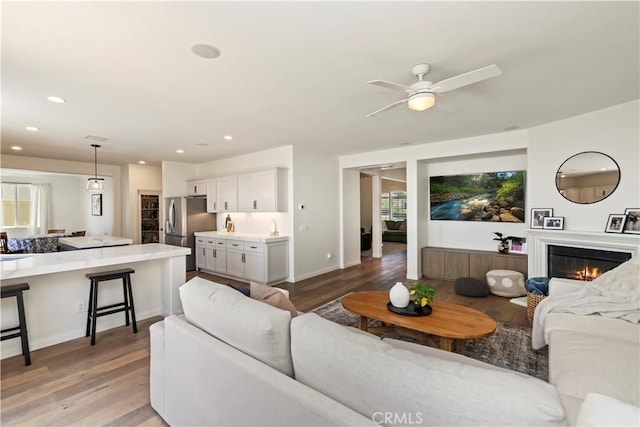 8581 Camino Limon Rd, Corona, CA 92883 - living room featuring light wood finished floors, ceiling fan, recessed lighting, a glass covered fireplace, and baseboards