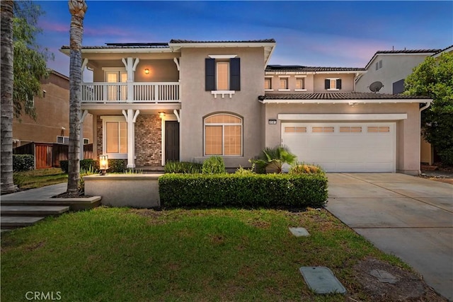 8581 Camino Limon Rd, Corona, CA 92883 - mediterranean / spanish-style home featuring a balcony, concrete driveway, roof mounted solar panels, stucco siding, and a garage