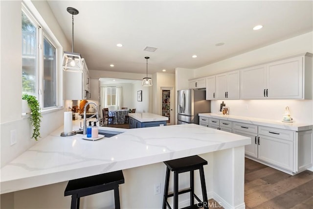 8581 Camino Limon Rd, Corona, CA 92883 - kitchen featuring stainless steel fridge with ice dispenser, a peninsula, a sink, white cabinetry, and recessed lighting