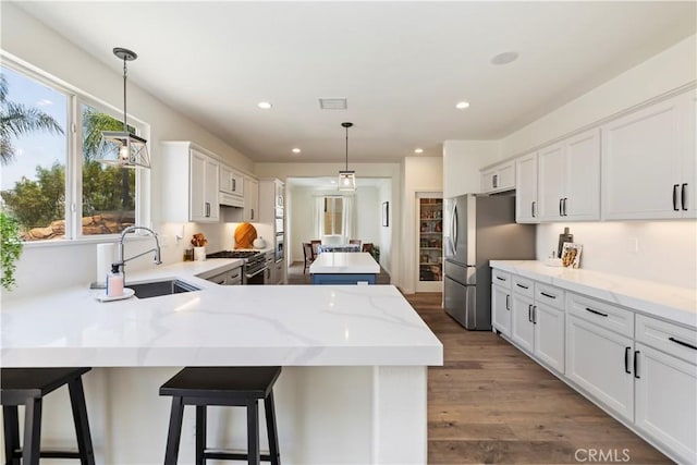 8581 Camino Limon Rd, Corona, CA 92883 - kitchen featuring a sink, appliances with stainless steel finishes, a peninsula, white cabinets, and a kitchen island
