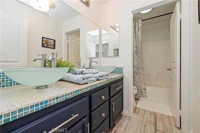 8581 Camino Limon Rd, Corona, CA 92883 - bathroom featuring double vanity, toilet, shower / bathtub combination with curtain, and wood finished floors