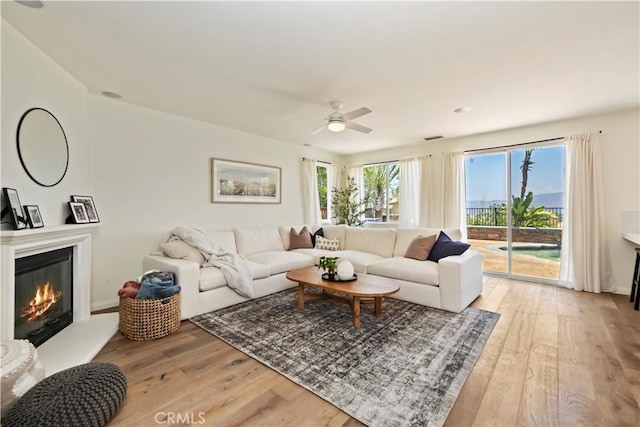 8581 Camino Limon Rd, Corona, CA 92883 - living room with a ceiling fan, light wood-style floors, and a glass covered fireplace