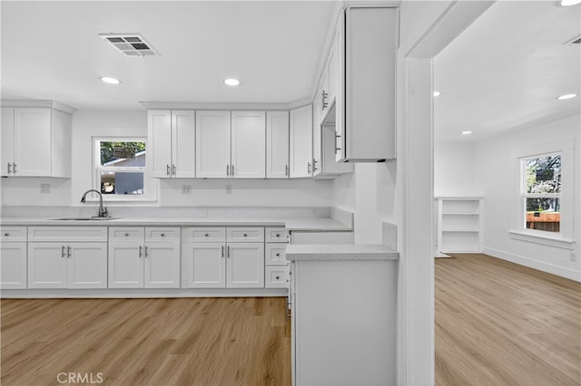 401 Cypress St, Bakersfield, CA 93304 - kitchen with light wood-style flooring, light countertops, plenty of natural light, white cabinetry, and recessed lighting