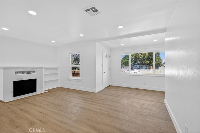401 Cypress St, Bakersfield, CA 93304 - unfurnished living room featuring a premium fireplace, recessed lighting, light wood-style flooring, and baseboards