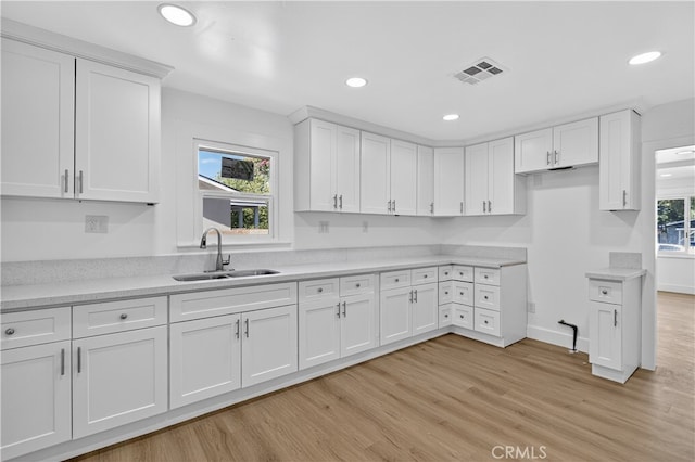 401 Cypress St, Bakersfield, CA 93304 - kitchen with a sink, white cabinets, light wood-type flooring, recessed lighting, and light countertops