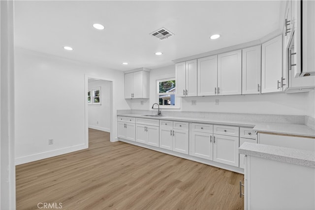 401 Cypress St, Bakersfield, CA 93304 - kitchen with light wood-type flooring, recessed lighting, white cabinets, and light stone countertops