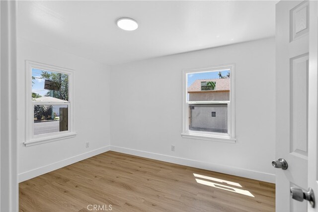 401 Cypress St, Bakersfield, CA 93304 - empty room with healthy amount of natural light, light wood finished floors, and baseboards