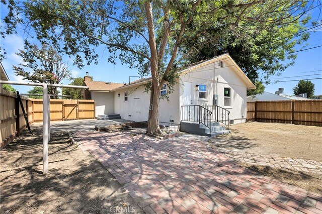 401 Cypress St, Bakersfield, CA 93304 - rear view of property with a patio, a fenced backyard, a gate, and stucco siding