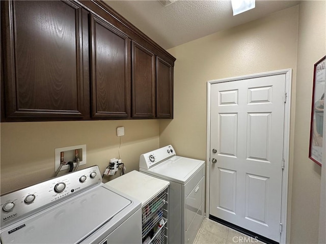 2408 Driftwood Dr, Rosamond, CA 93560 - laundry area with cabinet space, washer and dryer, a textured ceiling, and light tile patterned floors
