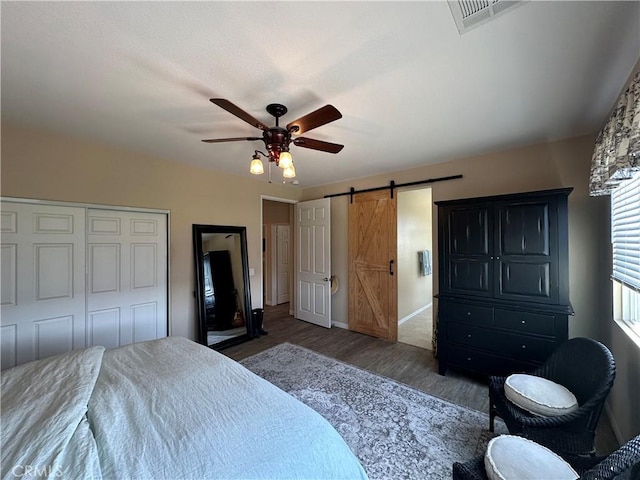2408 Driftwood Dr, Rosamond, CA 93560 - bedroom featuring wood finished floors, a barn door, baseboards, a ceiling fan, and a closet