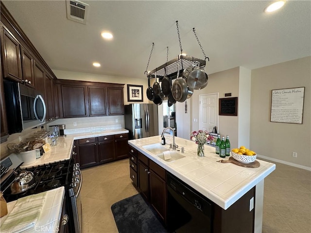 2408 Driftwood Dr, Rosamond, CA 93560 - kitchen with appliances with stainless steel finishes, a sink, light tile patterned floors, dark brown cabinetry, and recessed lighting