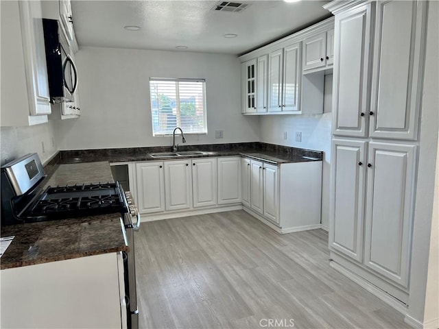 774 Josie St, Blythe, CA 92225 - kitchen with stainless steel appliances, a sink, light wood-style floors, white cabinets, and glass insert cabinets