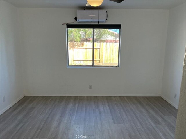 774 Josie St, Blythe, CA 92225 - spare room with an AC wall unit, wood finished floors, baseboards, and ceiling fan