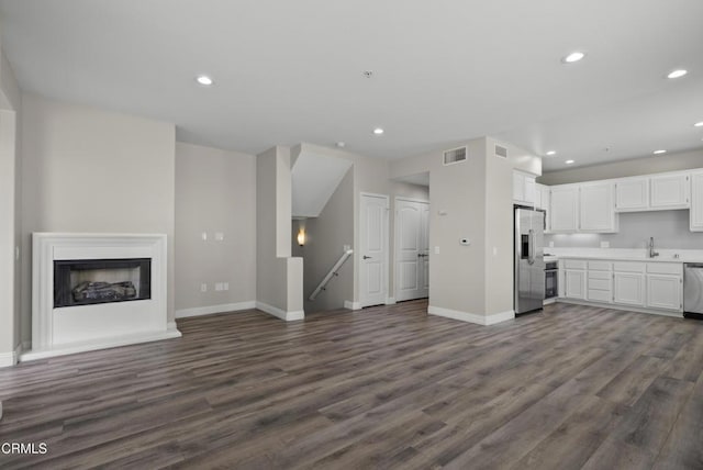1542 Windshore Way, Oxnard, CA 93035 - unfurnished living room featuring baseboards, dark wood-style flooring, recessed lighting, a fireplace, and a sink