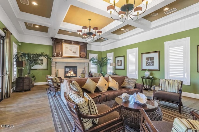 1542 Windshore Way, Oxnard, CA 93035 - living area featuring a chandelier, coffered ceiling, baseboards, a glass covered fireplace, and light wood-style floors