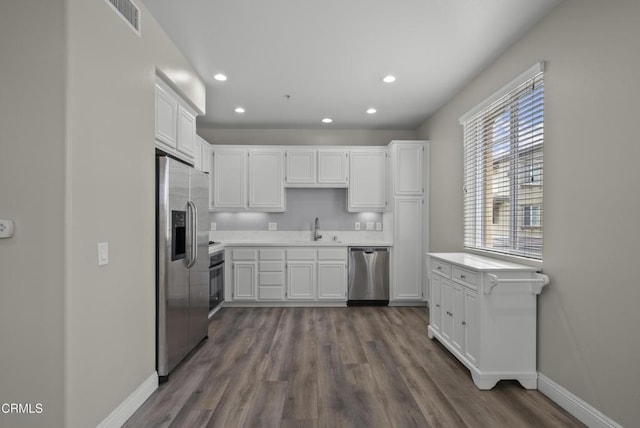 1542 Windshore Way, Oxnard, CA 93035 - kitchen with appliances with stainless steel finishes, white cabinets, dark wood-style flooring, recessed lighting, and light countertops