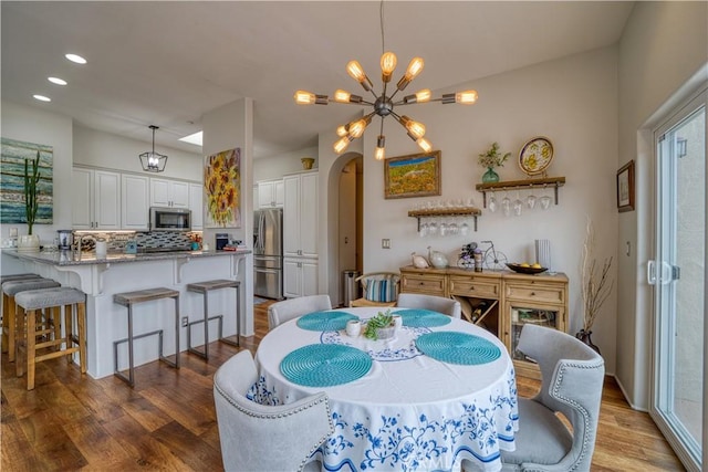 516 Stoneridge Dr, San Luis Obispo, CA 93401 - dining area with arched walkways, wood finished floors, a chandelier, and recessed lighting
