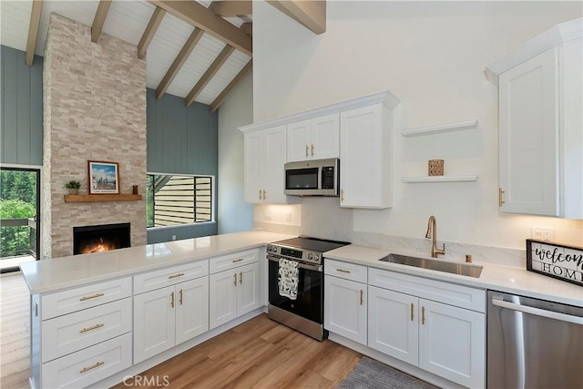 27657 Peninsula Dr Unit 131, Lake Arrowhead, CA 92352 - kitchen with appliances with stainless steel finishes, a peninsula, open shelves, high vaulted ceiling, and light countertops