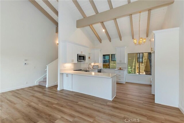 27657 Peninsula Dr Unit 131, Lake Arrowhead, CA 92352 - kitchen featuring stainless steel microwave, high vaulted ceiling, beam ceiling, a chandelier, and light countertops