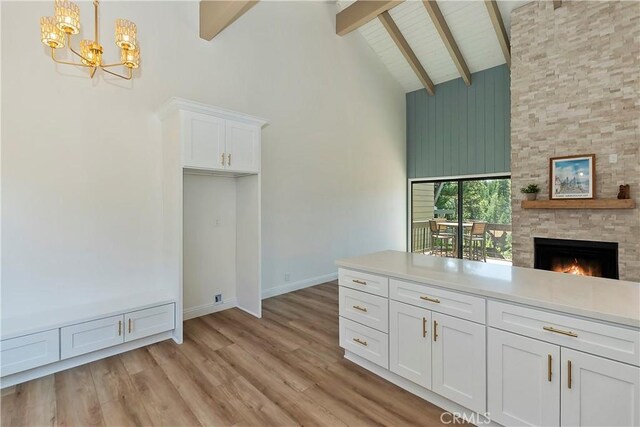27657 Peninsula Dr Unit 131, Lake Arrowhead, CA 92352 - unfurnished dining area with high vaulted ceiling, beamed ceiling, light wood-type flooring, a chandelier, and a fireplace