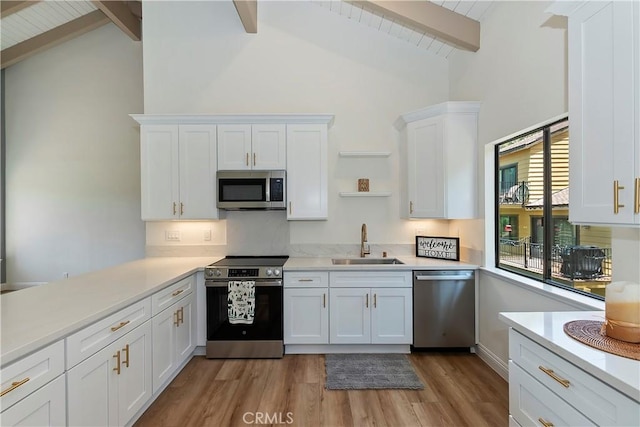 27657 Peninsula Dr Unit 131, Lake Arrowhead, CA 92352 - kitchen featuring stainless steel appliances, light wood finished floors, white cabinetry, light countertops, and high vaulted ceiling