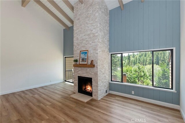 27657 Peninsula Dr Unit 131, Lake Arrowhead, CA 92352 - unfurnished living room with high vaulted ceiling, wood finished floors, a fireplace, and a wooden ceiling with exposed beams